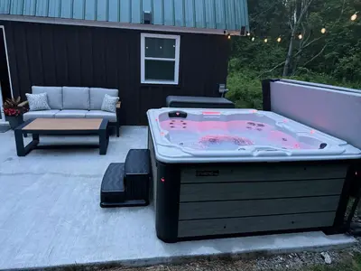 a large jacuzzi tub sitting on a patio at Private Cottage with Hot Tub in the Woods in Thompson