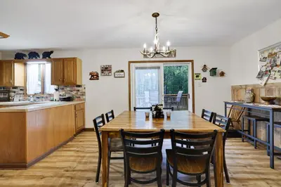 a kitchen and dining room with a wooden table and chairs at Serenity and Fun all in one in this Cozy Pocono Cabin in Jim Thorpe