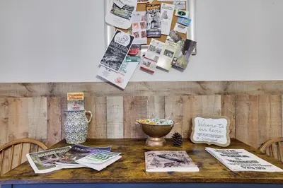 a wooden table with magazines and newspapers on it at Serenity and Fun all in one in this Cozy Pocono Cabin in Jim Thorpe