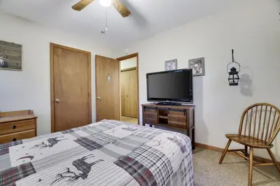 a bedroom with a bed and a flat screen tv at Serenity and Fun all in one in this Cozy Pocono Cabin in Jim Thorpe