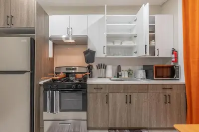 a kitchen with white cabinets and a stove top oven at 2 Days Stay Get 40 percent OFF for, Sleeps 6 & 2 Queen in Newark