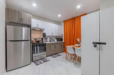 a kitchen with a stainless steel refrigerator and a table at 2 Days Stay Get 40 percent OFF for, Sleeps 6 & 2 Queen in Newark