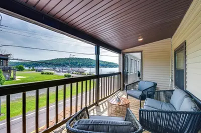 a balcony with two chairs and a view of the water at Modern Harveys Lake Apartment with Beach Access! in Harveys Lake