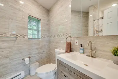 a bathroom with a toilet and a sink and a mirror at Modern Harveys Lake Apartment with Beach Access! in Harveys Lake