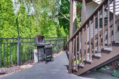 a grill sitting on a porch next to a fence at Modern Harveys Lake Apartment with Beach Access! in Harveys Lake