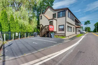 a house on the side of a road next to a building at Modern Harveys Lake Apartment with Beach Access! in Harveys Lake