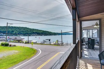 a house with a balcony with a view of the water at Modern Harveys Lake Apartment with Beach Access! in Harveys Lake