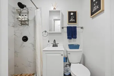 a white bathroom with a toilet and a sink at Highly Recommended Studio Near Times Square in New York