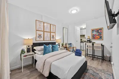 a bedroom with a large bed with blue pillows at Highly Recommended Studio Near Times Square in New York