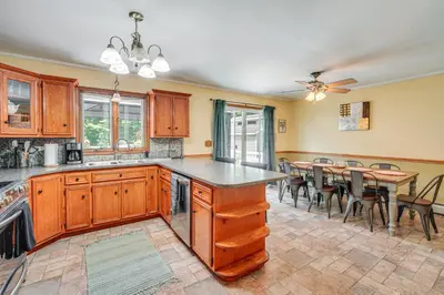 a kitchen with wooden cabinets and a table with chairs at Game Room and Private Yard Family Gem in Kunkletown in Effort