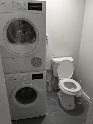 a bathroom with a washing machine and a toilet at Extended Family Stay in Passaic