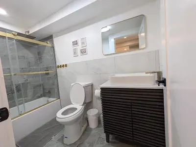 a bathroom with a toilet and a sink and a shower at Extended Family Stay in Passaic