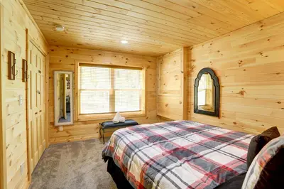 a bedroom with a bed in a wooden cabin at NEW Construction - 7 Bedroom Log Cabin in Blakeslee