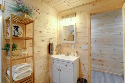 a bathroom with a sink and a mirror at NEW Construction - 7 Bedroom Log Cabin in Blakeslee