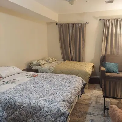 a bedroom with two beds and a chair at Double queen room 6 minutes walk to Penn station NYC EWR in Jersey City