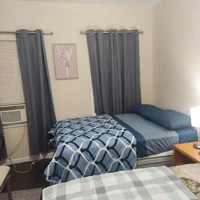 a bedroom with two beds and a window with curtains at Double queen room 6 minutes walk to Penn station NYC EWR in Jersey City
