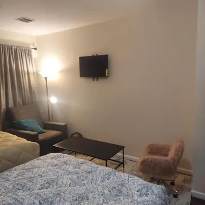 a hotel room with a bed and a tv on the wall at Double queen room 6 minutes walk to Penn station NYC EWR in Jersey City