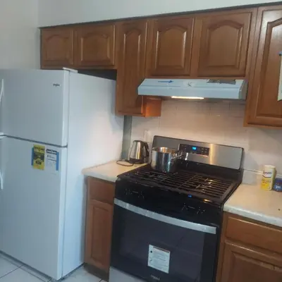 a kitchen with a stove and a white refrigerator at Double queen room 6 minutes walk to Penn station NYC EWR in Jersey City