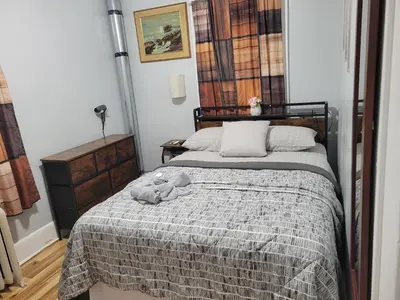 a bedroom with a bed with a gray blanket at Comfortable in Roselle