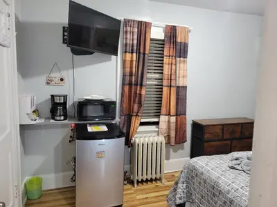 a small room with a refrigerator and a bed at Comfortable in Roselle