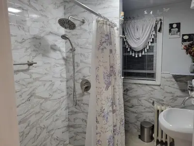 a bathroom with a shower curtain and a sink at Comfortable in Roselle