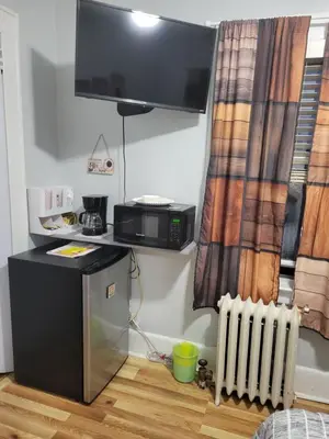 a room with a microwave and a tv on the wall at Comfortable in Roselle
