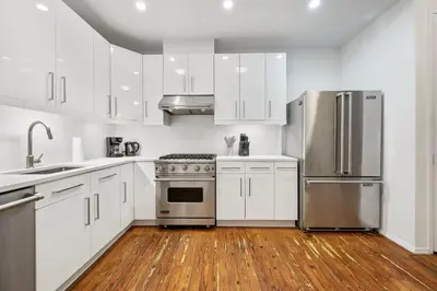a kitchen with white cabinets and stainless steel appliances at Massive SoHo Loft 4 Bedrooms 2 Bath 8 beds in New York