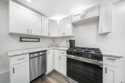 a kitchen with white cabinets and a stove top oven at Jetted Tub Stay in Passaic