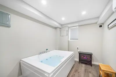 a white bathroom with a tub and a fireplace at Jetted Tub Stay in Passaic