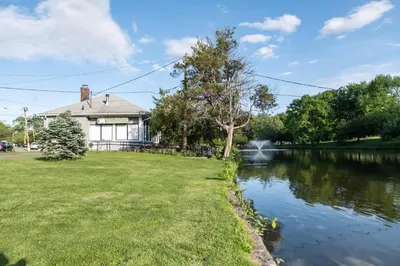 a house with a pond in front of it at Jetted Tub Stay in Passaic
