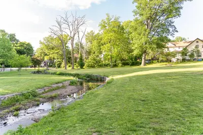 a river in a park next to a grass field at Jetted Tub Stay in Passaic