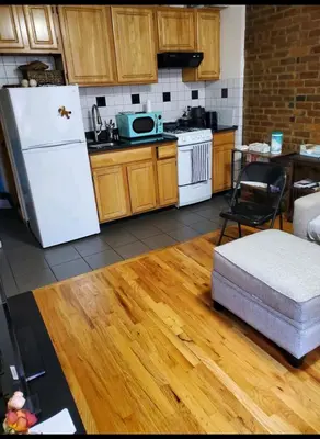 a kitchen with a white refrigerator and a wooden floor at Conveniently located in the heart of the city in New York