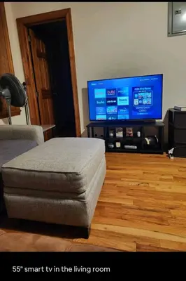 a living room with a tv and a ottoman at Conveniently located in the heart of the city in New York