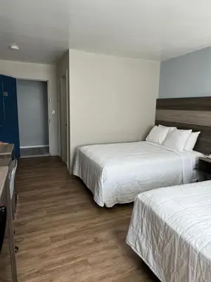 a hotel room with two beds with white sheets at Ritz Motel in Elizabeth