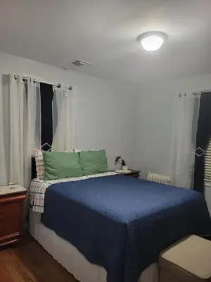 a bedroom with a bed with a blue blanket at New bedroom in Roselle