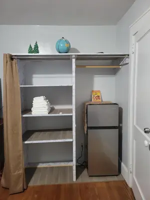 a book shelf in a room with a refrigerator at New bedroom in Roselle