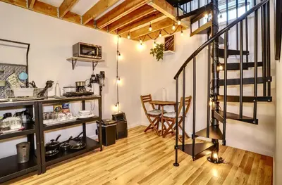 a room with a staircase and a table and chairs at NYC Loft Studio Near MetLife World Cup Stadium & Times Square in North Bergen