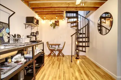 a room with a spiral staircase and a table at NYC Loft Studio Near MetLife World Cup Stadium & Times Square in North Bergen