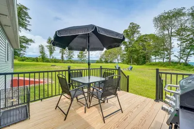 a table and chairs on a deck with an umbrella at Comfortable Muncy Home with Serene Views! in Muncy