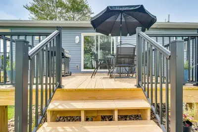 a wooden deck with a table and an umbrella at Comfortable Muncy Home with Serene Views! in Muncy