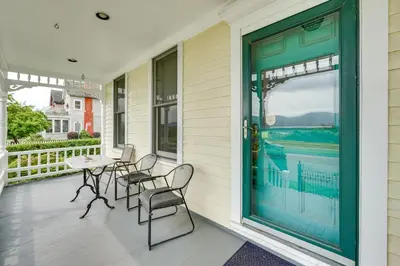 a front porch with chairs and a table and a door at Walk to Hudson River Pet-Friendly Home with Views! in Newburgh