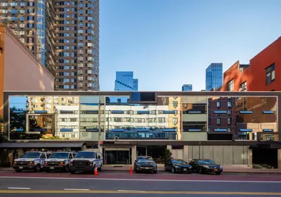 a parking lot with cars parked in front of a building at Hudson Yards Hotel in New York