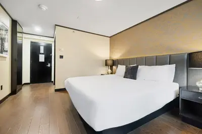 a bedroom with a large white bed with a large headboard at Hudson Yards Hotel in New York