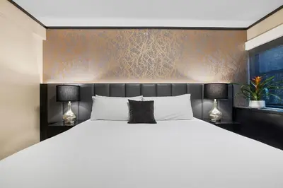 a bedroom with a large white bed with two lamps at Hudson Yards Hotel in New York