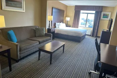 a hotel room with a couch and a bed at Wingate by Wyndham Harrisburg Near Hershey in Harrisburg