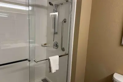 a bathroom with a shower with a glass door at Wingate by Wyndham Harrisburg Near Hershey in Harrisburg