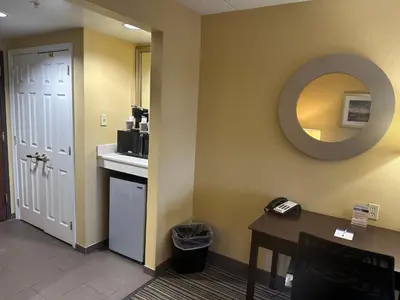 a room with a table and a mirror on the wall at Wingate by Wyndham Harrisburg Near Hershey in Harrisburg