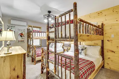 a bedroom with two bunk beds and a desk at Forest Views and Hot Tub Poconos Cozy Cabin in Albrightsville