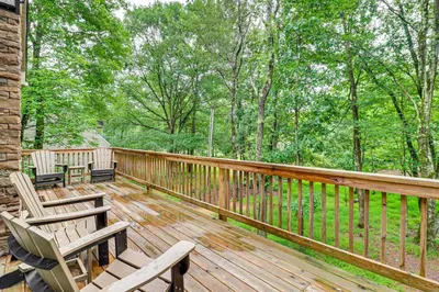 a wooden deck with chairs and trees on it at Forest Views and Hot Tub Poconos Cozy Cabin in Albrightsville