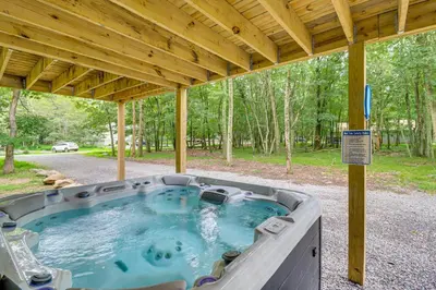 a hot tub under a pavilion in the woods at Forest Views and Hot Tub Poconos Cozy Cabin in Albrightsville